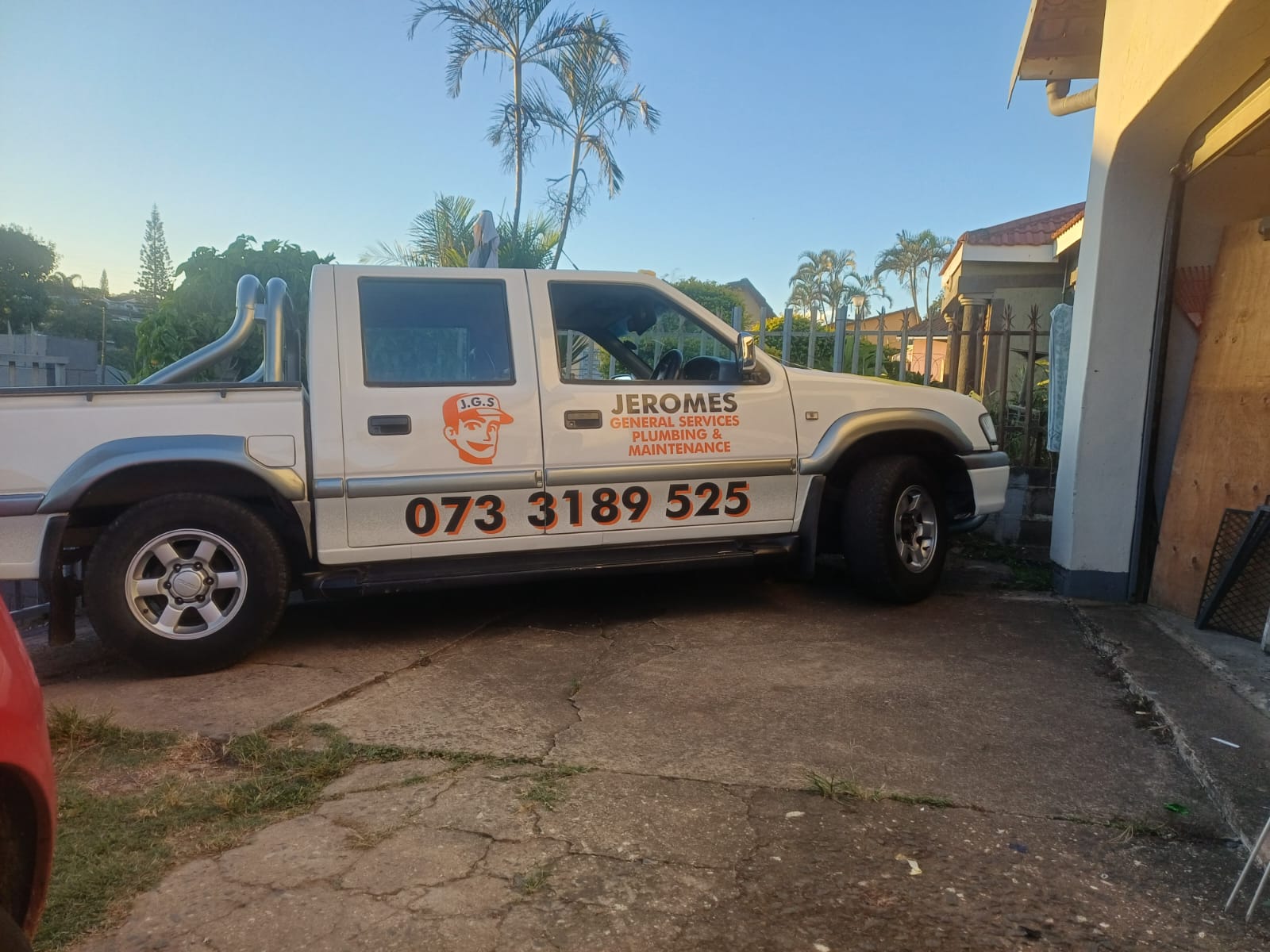 Jerome, qualified plumber, standing beside the branded Jerome's General Services bakkie